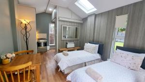 1 dormitorio con 2 camas, mesa y cocina en Golilli Studio Accommodation Clare, en Newmarket on Fergus