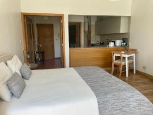 um quarto com uma grande cama branca e uma cozinha em Douro River Cozy Flats no Porto