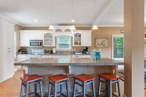 a kitchen with a large island with red bar stools at Lake Sinclair in Eatonton