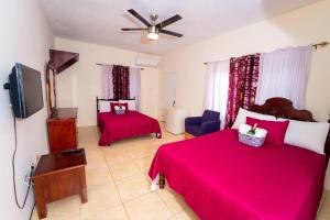 a large room with two beds and a television at Villa Suites in Runaway Bay in Runaway Bay