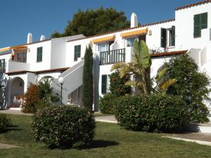 a white building with bushes in front of it at Nure Mar y Mar in Cala en Blanes