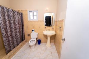 a bathroom with a toilet and a sink at Villa Suites in Runaway Bay in Runaway Bay