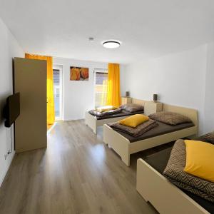 two beds in a room with yellow curtains at Ferienwohnung Istanbul nähe Legoland in Günzburg