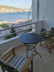 a table and chairs on a balcony with a view of the ocean at Saranda porti in Sarandë