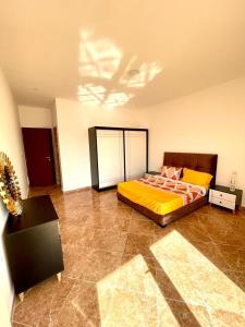 1 dormitorio con cama con sábanas amarillas y techo en Residence guessab, en Orán