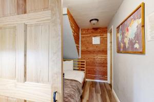 um pequeno quarto com uma cama e paredes de madeira em Casa Feliz em Tahoe Vista