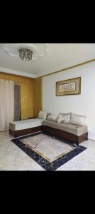 Großes Zimmer mit 2 Betten und einem Kronleuchter in der Unterkunft Résidence Abdel Rahman in Mostaganem