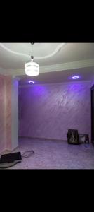 ein leeres Zimmer mit einer lila Wand und einer Decke in der Unterkunft Résidence Abdel Rahman in Mostaganem
