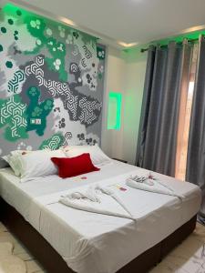 Un dormitorio con una cama con una pared verde y blanca en SAPHYR GROUP HOTELIER en Duala