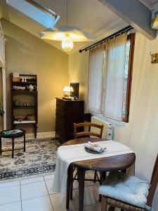 een woonkamer met een tafel en een stoel bij Maisonnette individuelle au coeur de Vernon in Vernon