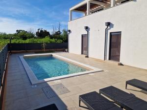 a swimming pool in the backyard of a house at Apartmani Relaxsea in Privlaka