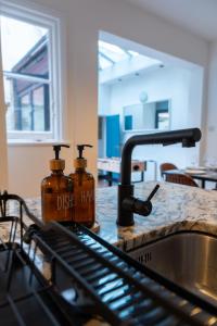 a kitchen counter with two bottles on a sink at Chiswick 4 Bed Victorian Townhouse Minutes to Tube in London