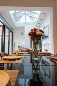 a dining room with wine glasses and a vase of flowers at Chiswick 4 Bed Victorian Townhouse Minutes to Tube in London
