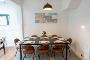 a dining room with a black table and chairs at Chiswick 4 Bed Victorian Townhouse Minutes to Tube in London