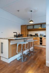 a kitchen with two bar stools at a counter at Chiswick 4 Bed Victorian Townhouse Minutes to Tube in London