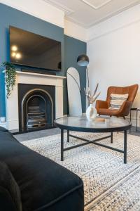 a living room with a coffee table and a fireplace at Chiswick 4 Bed Victorian Townhouse Minutes to Tube in London