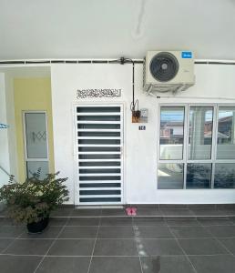 pared blanca con puerta y ventilador en AFA Homestay, en Kuala Kubu Baharu