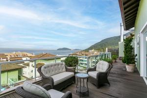 Un balcón con sillas y vistas al océano. en Cobertura Frente MAR no Santinho | Piscina #CSA03 en Florianópolis