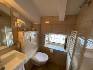 uma casa de banho com um lavatório, um WC e uma janela. em Bed and Breakfast Palac em Valun