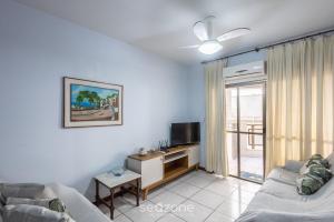 a living room with a couch and a tv at Apto c/ varanda - beira mar a Meia Praia CEO0104 in Meia Praia
