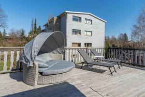 une chaise en osier et deux chaises sur une terrasse dans l'établissement Sepa House with Private Garden, à Pärnu