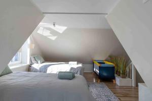 - une chambre mansardée avec 2 lits et une fenêtre dans l'établissement Sepa House with Private Garden, à Pärnu