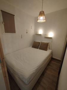 ein kleines Schlafzimmer mit einem weißen Bett in einem Zimmer in der Unterkunft Mimi&Cosy, appartement en bord de mer à Six-Fours-les-plages in Six-Fours-les-Plages + 39 Fotos