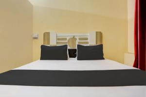 a bedroom with a large bed with black pillows at OYO Flagship Hotel Suraj Villa in Nārnaul