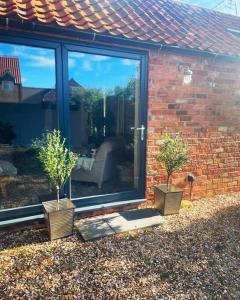 una casa con dos macetas delante de una ventana en The Grey Barn en Scampton