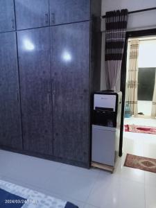 eine Küche mit Holzschränken und einer Mikrowelle im Zimmer in der Unterkunft One Bed Furnished Apartment in Karatschi
