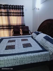 una camera da letto con un letto con una trapunta blu sopra di One Bed Furnished Apartment a Karachi