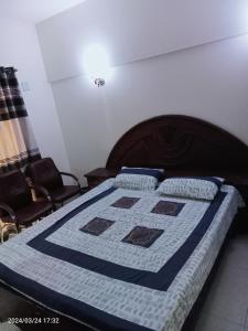 ein Bett mit einer blau-weißen Decke drauf in der Unterkunft One Bed Furnished Apartment in Karatschi