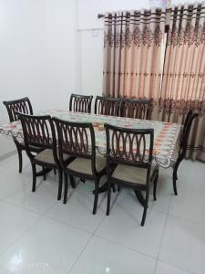einen Esstisch und Stühle mit Vorhängen in der Unterkunft One Bed Furnished Apartment in Karatschi