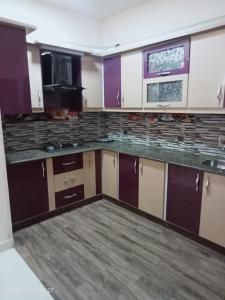 una cucina vuota con armadi viola e bianchi di One Bed Furnished Apartment a Karachi