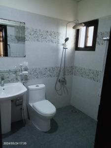 bagno con servizi igienici bianchi e lavandino di One Bed Furnished Apartment a Karachi