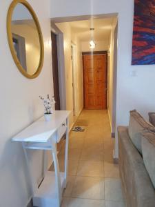Novel 1-Bedroom in Madaraka Estate, Nairobi في نيروبي: غرفة معيشة مع طاولة بيضاء ومرآة