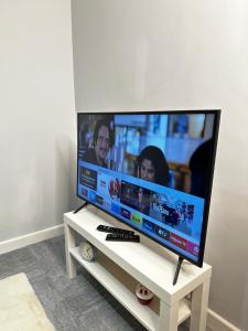 a large flat screen tv sitting on a white stand at Cozy Studio Kelham Island in Oughtibridge