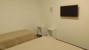 a room with two beds and a flat screen tv at HOTEL ARANDÚ in Villaguay