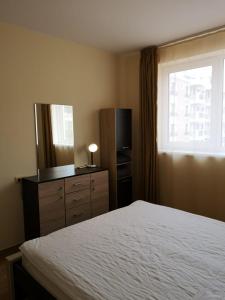 a bedroom with a bed and a dresser and a window at Sveti Vlas Sky Dreams Apartment in Sveti Vlas