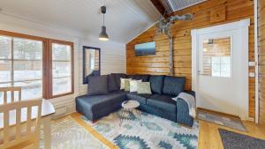 a living room with a blue couch and wooden walls at Levin Rankis in Kittilä