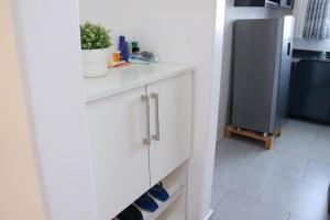 a kitchen with white cabinets and a refrigerator at Kigali Fantastic Apartment in Kigali
