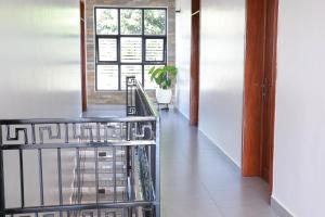 キガリにあるKIGALI FANTASTIC APARTMENTsの窓と植物のある階段のある廊下