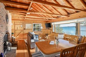a living room with a table and a fireplace at Omena Point Paradise Waterfront Sunrise in Suttons Bay