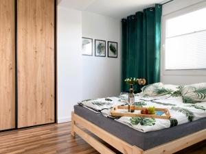 - une chambre avec un lit et un plateau de fruits dans l'établissement Apartamenty Dostoja, à Władysławowo