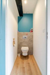 a bathroom with a toilet and a blue wall at Gîte à la campagne Les Ch'tis Normands 