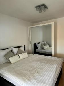 Schlafzimmer mit einem großen weißen Bett und einem Spiegel in der Unterkunft Haus Ella in Novi Vinodolski