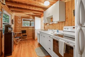 a kitchen with white appliances and wooden walls at Omena Point Paradise Waterfront Sunrise in Suttons Bay