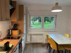 a kitchen with a table and chairs and a window at Apartman Sutla in Kumrovec