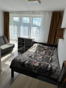 sypialnia z łóżkiem, komodą i oknem w obiekcie Pokoje i apartamenty Aga Centrum w Wiśle