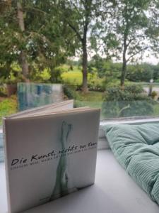 a book sitting on a window sill with a laptop at Lille Lykke2 - Direkt am Golfplatz & Nahe Grömitz & Strand in Schashagen
